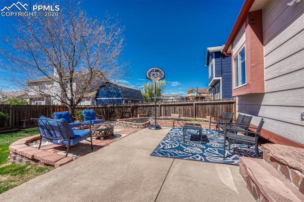 Image 35 of 40: Concrete patio with a wood privacy fence 