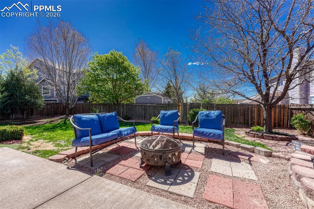 Image 36 of 40: Expansive backyard featuring a concrete patio, paver stones, a fire pit, a 
