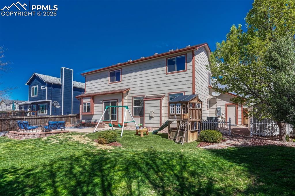 Image 39 of 40: Expansive fenced backyard featuring a manicured lawn, a large paver patio, 