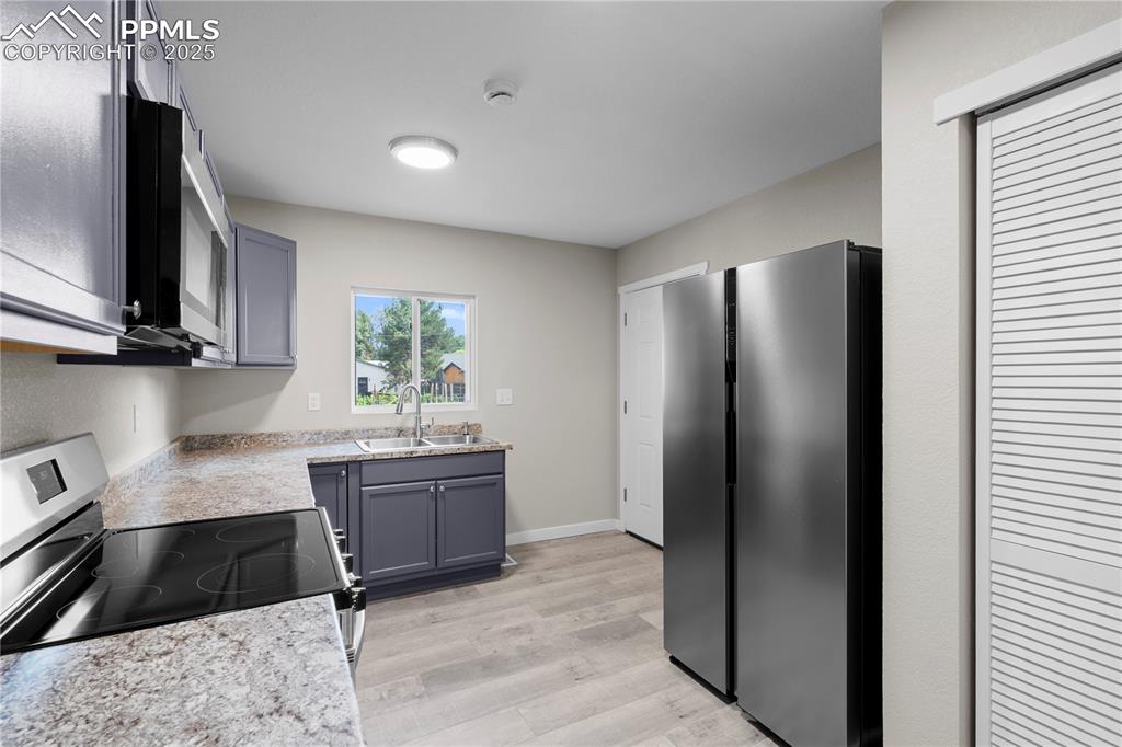 Image 10 of 25: Kitchen featuring appliances with stainless steel finishes, light counterto