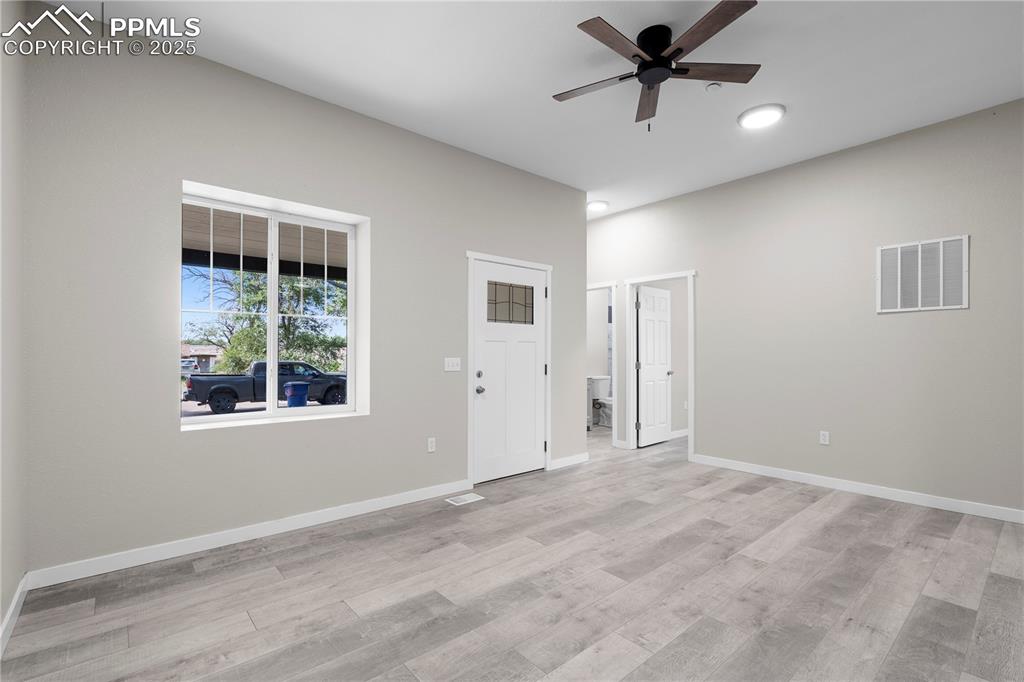 Image 11 of 25: Unfurnished room featuring a ceiling fan, light wood finished floors, and r
