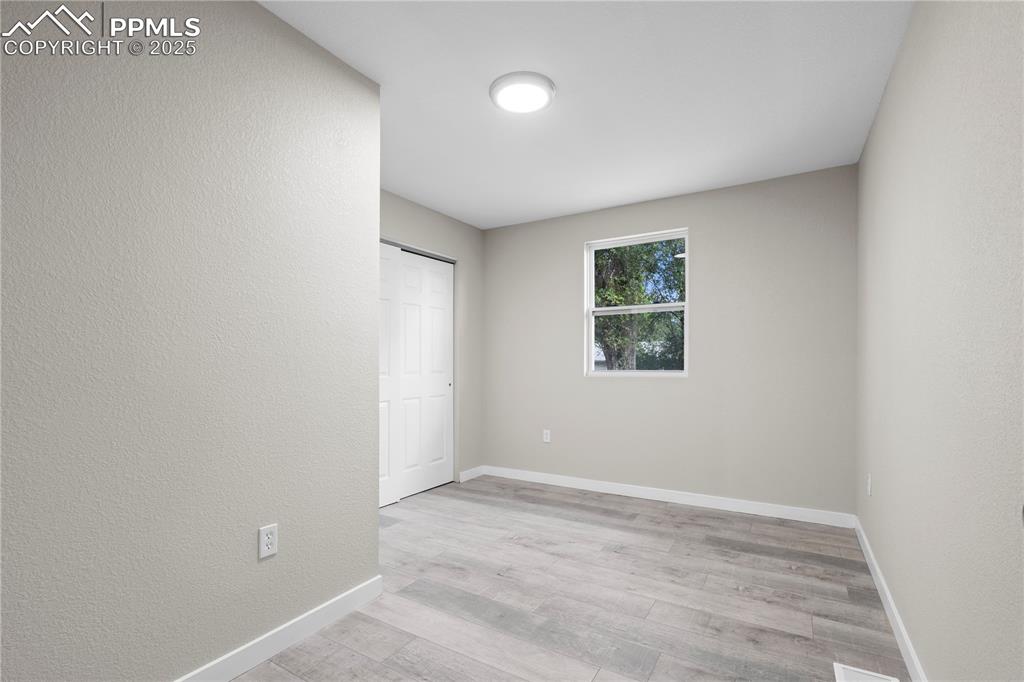 Image 16 of 25: Unfurnished bedroom featuring light wood-type flooring and a closet