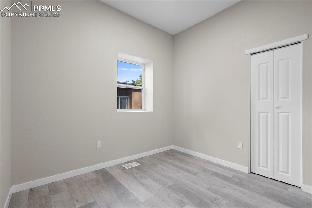 Image 20 of 25: Spare room with light wood-style flooring and baseboards