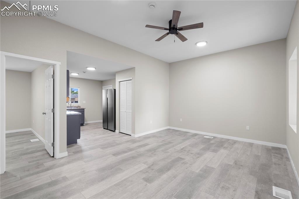 Image 21 of 25: Unfurnished living room with a ceiling fan, light wood-type flooring, and r