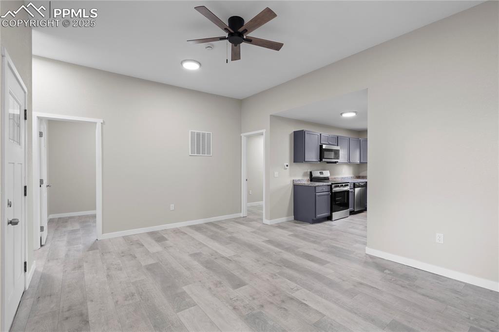 Image 22 of 25: Unfurnished living room with ceiling fan and light wood finished floors