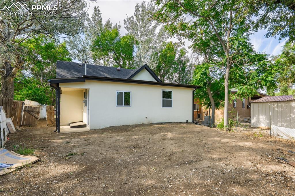 Image 4 of 25: Back of house with stucco siding and a shingled roof