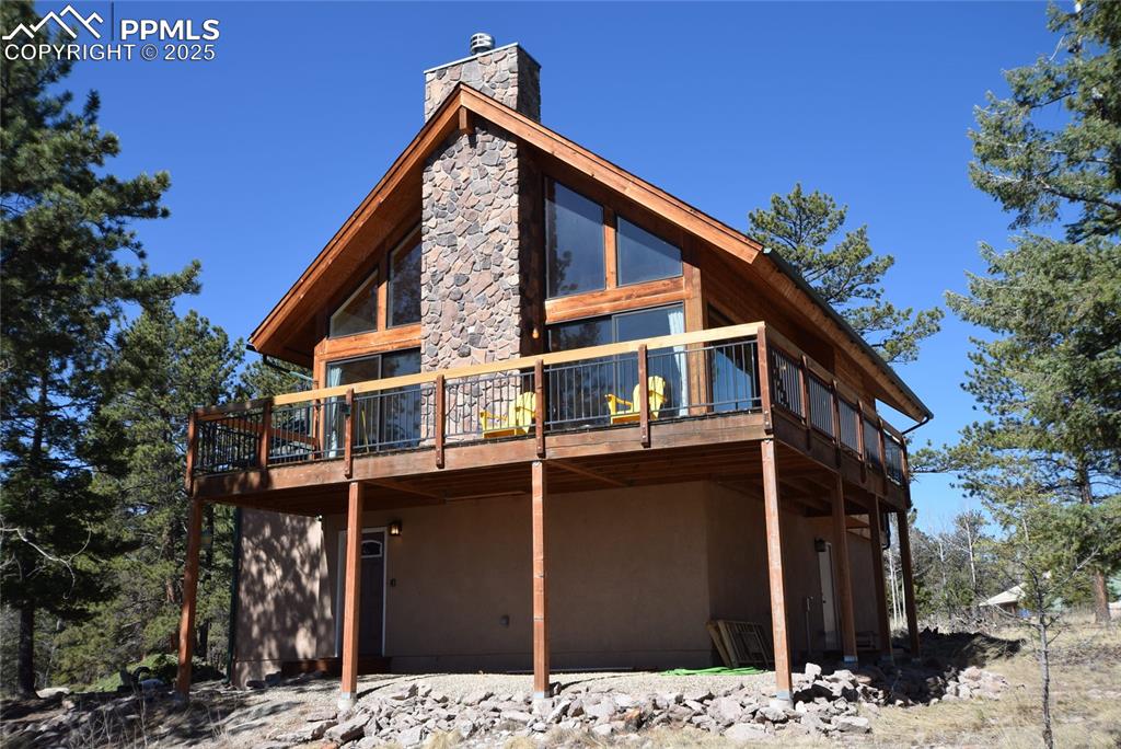 Caption: View of side of property with a deck and a chimney