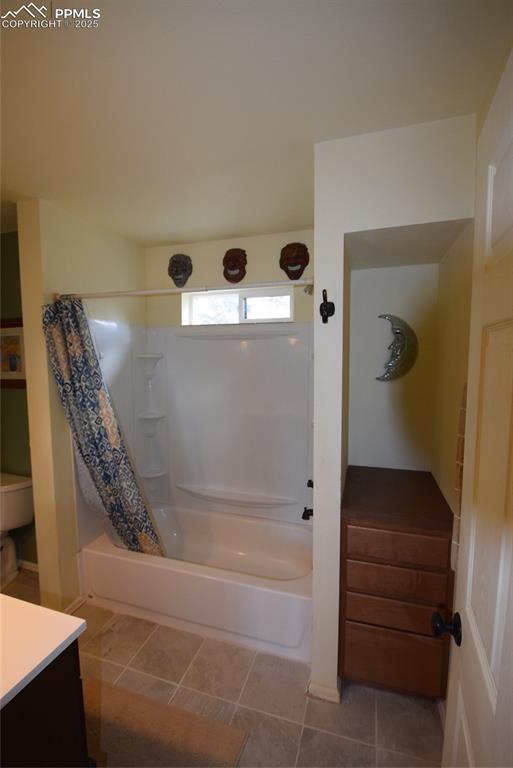 Image 26 of 44: Bathroom featuring shower / tub combo, vanity, and light tile patterned flo