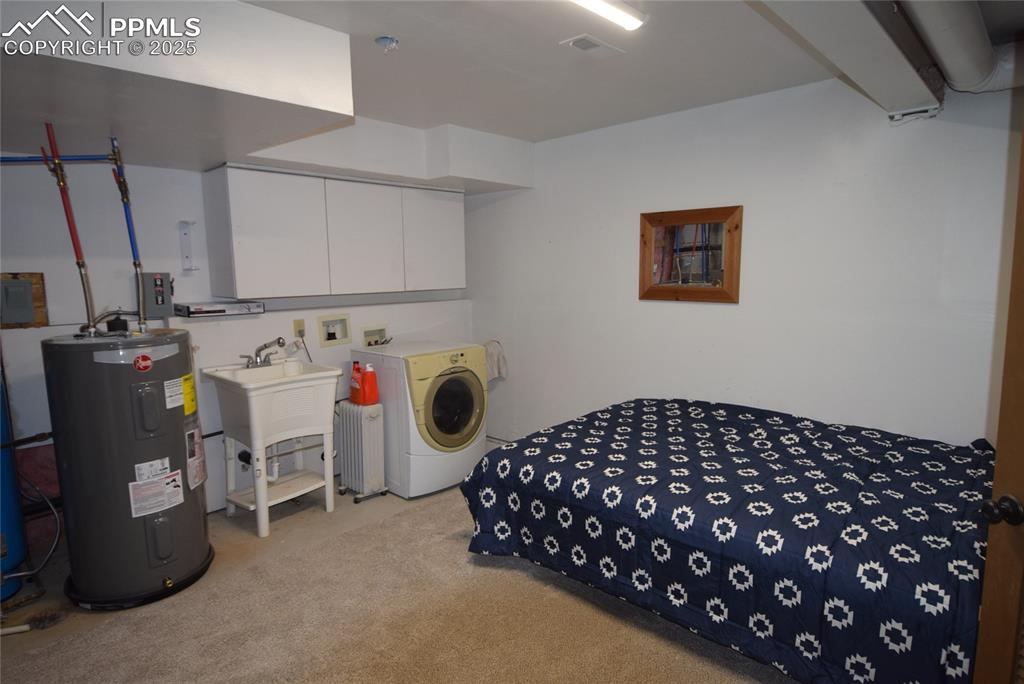 Image 30 of 44: Bedroom featuring water heater, washer / clothes dryer, and light colored c