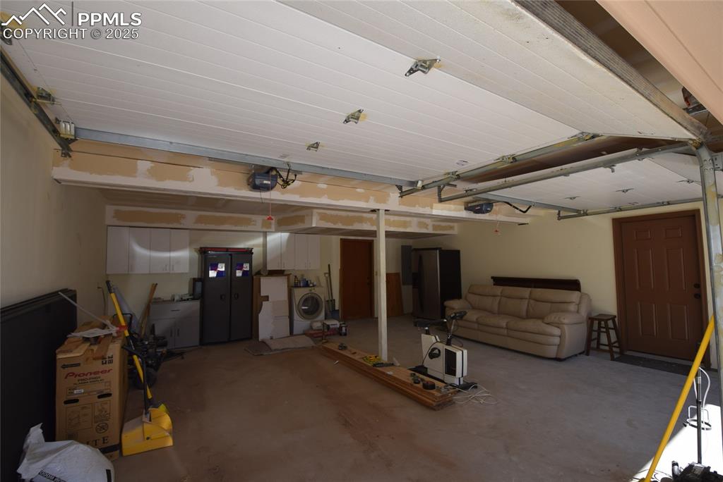 Image 33 of 44: Garage with washer / clothes dryer and a garage door opener