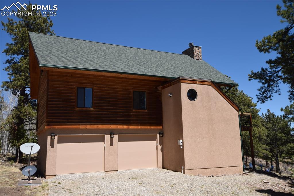 Image 5 of 44: Garage featuring gravel driveway