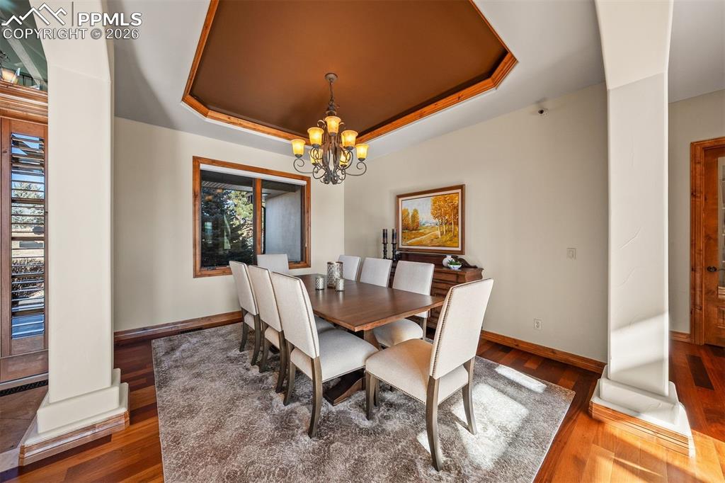 Image 10 of 40: An elegant dining room defined by a tray ceiling with rich wood detailing,