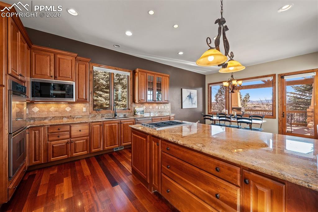 Image 14 of 40: Kitchen with granite counters, wood cabinets, a large center island, and a