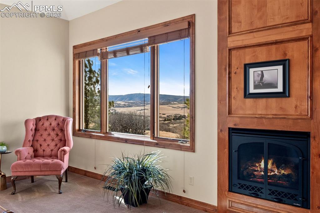Image 19 of 40: Primary bedroom sitting area featuring mountain views and a gas fireplace w