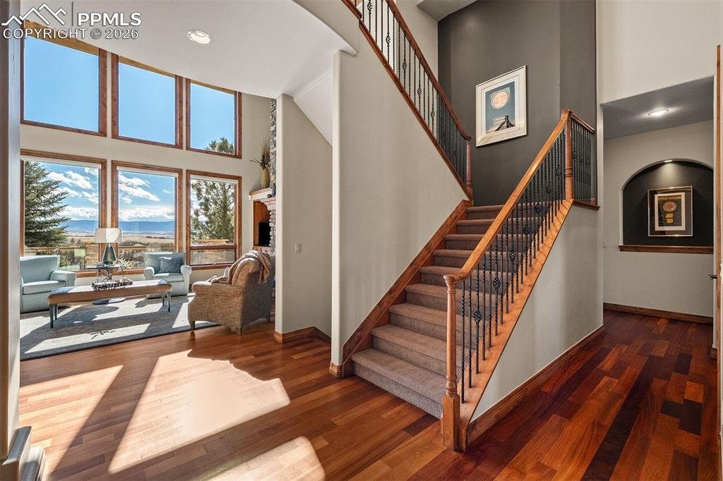 Image 26 of 40: Staircase with wood handrails and iron balusters overlooking the light fill