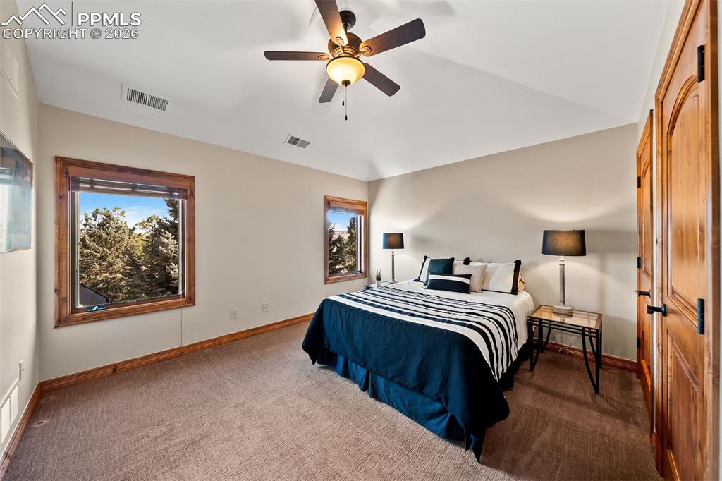 Image 30 of 40: Upper level bedroom (bedroom 4) with plush carpeting, dual windows, and an