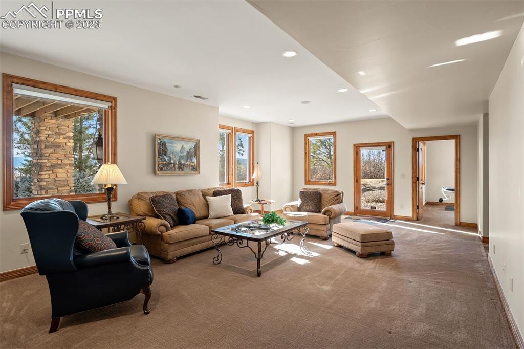 Image 32 of 40: Family room located on the lower level with expansive windows capturing bea