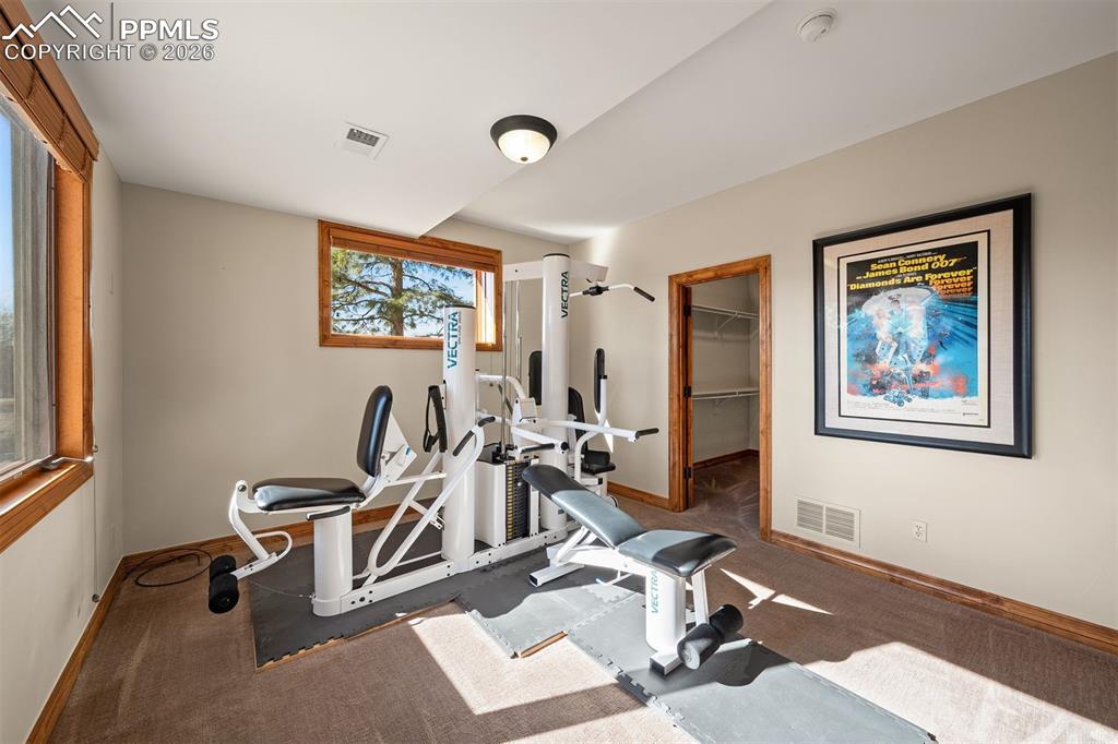 Image 36 of 40: Large bedroom (bedroom 6) currently used as a work out room with a walk-in