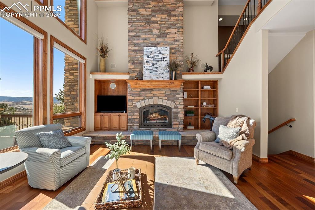 Image 6 of 40: Great room with soaring ceilings, a floor to ceiling stone fireplace, and e