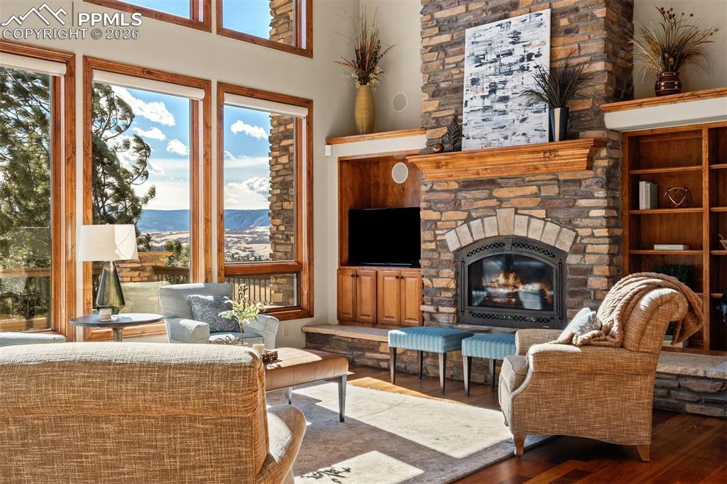Image 7 of 40: Great room anchored by a floor to ceiling stone fireplace with expansive wi