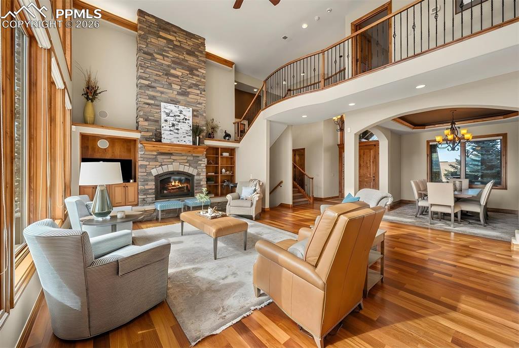 Image 9 of 40: Great room showcasing soaring ceilings, a dramatic stone fireplace, and an
