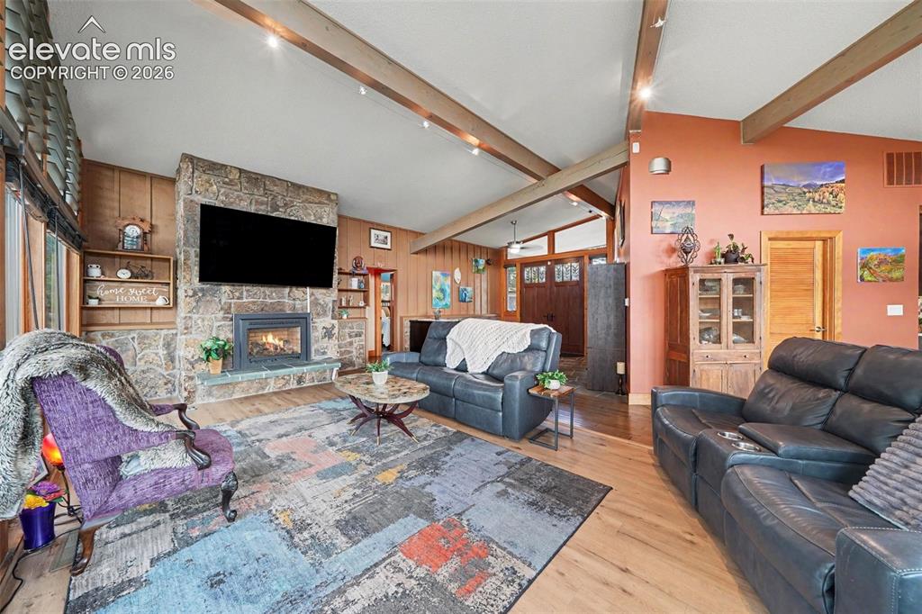 Image 10 of 30: A stunning floor-to-ceiling moss rock gas fireplace serves as the focal poi