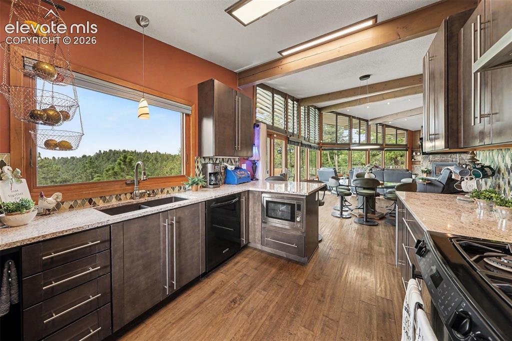 Image 14 of 30: Beautiful granite countertops, a gas range, and a multifunction microwave m