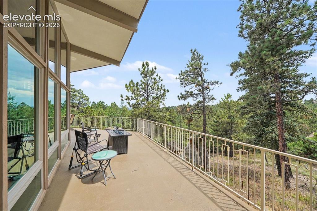 Image 22 of 30: Surrounded by mature trees, this open-air retreat provides peaceful views a