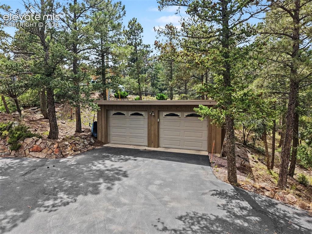 Image 7 of 30: The garage features abundant storage space, making it ideal for tools, outd