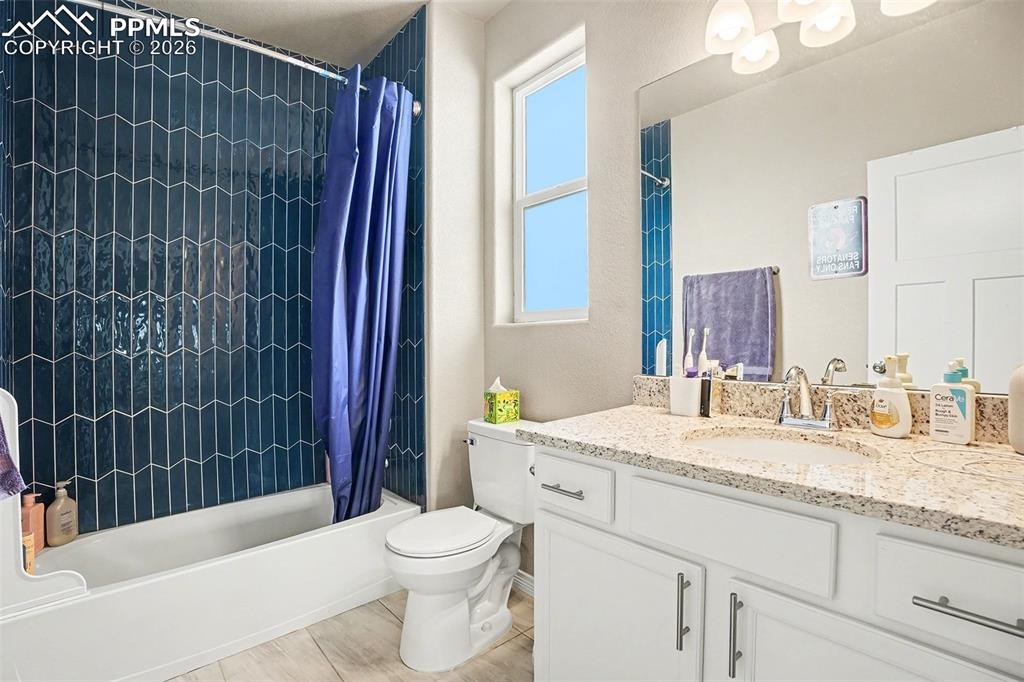 Image 18 of 35: Full bath with shower / bath combo with shower curtain and vanity