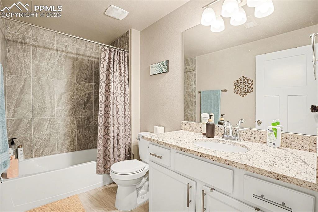 Image 23 of 35: Full bath featuring shower / bath combo, vanity, and a textured wall