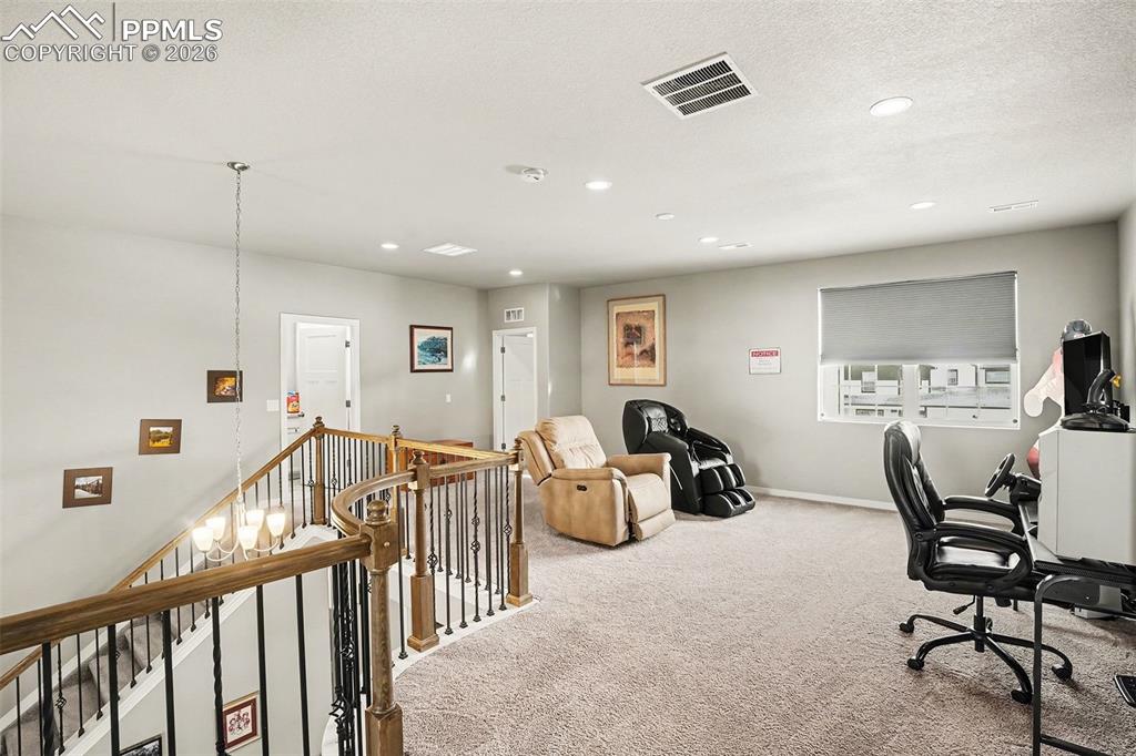 Image 9 of 35: Carpeted office space with a chandelier, recessed lighting, and a textured 