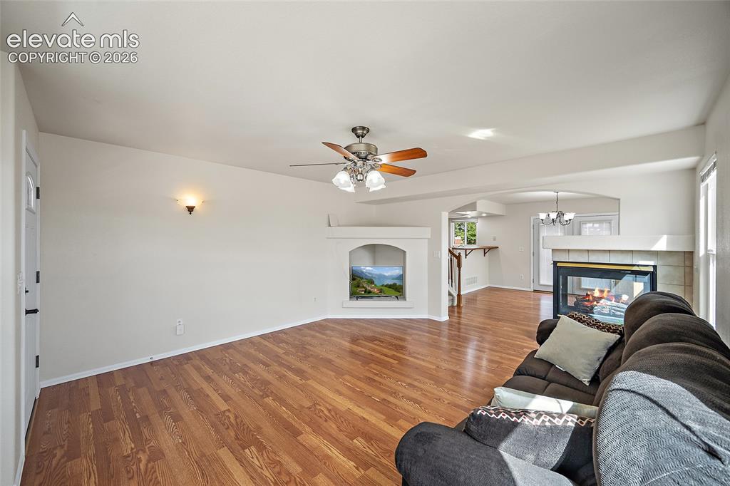 Image 11 of 41: Open-concept main level with hardwood flooring, generous living space, thre