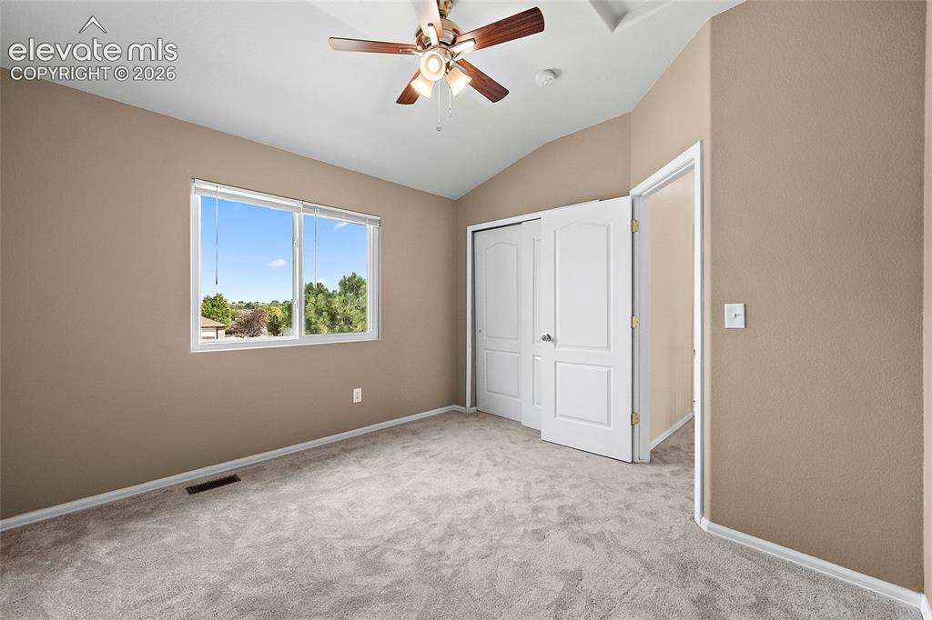 Image 18 of 41: Alternate angle of the upstairs bedroom highlighting the closet space, vaul