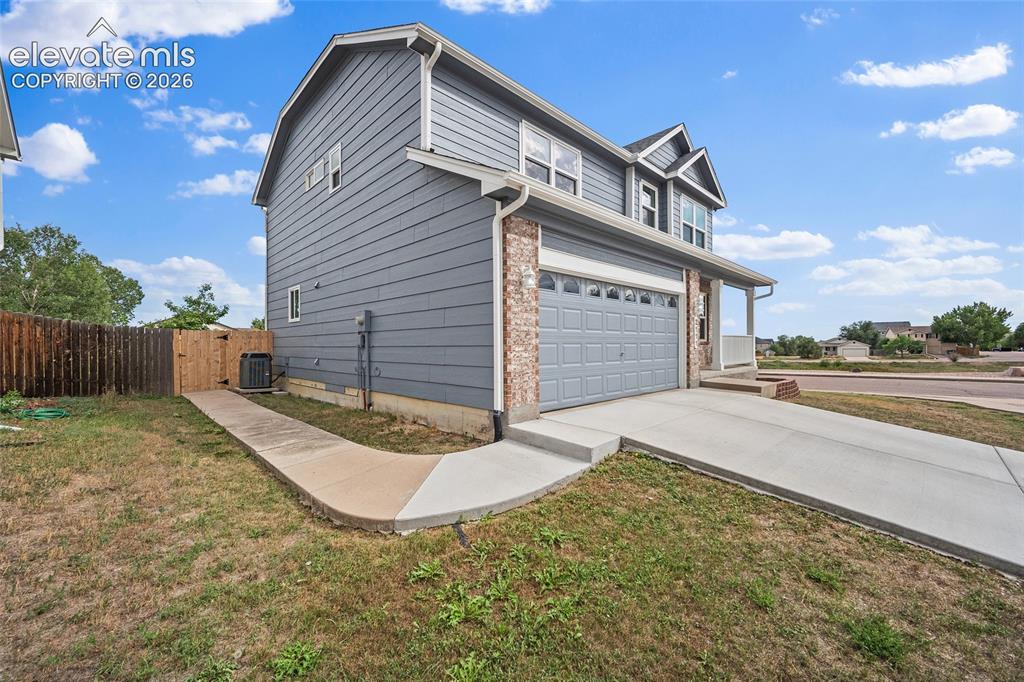 Image 2 of 41: Daytime exterior view showcasing the two-story design, attached two-car gar
