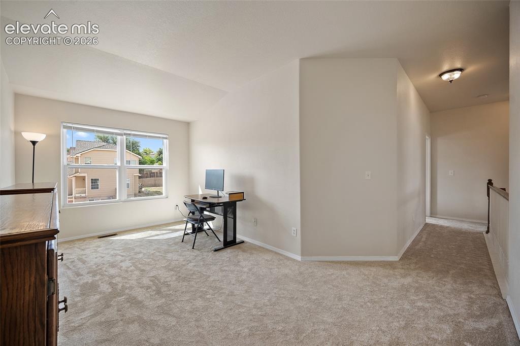 Image 20 of 41: Bright upper-level loft offering versatile bonus space with large windows,