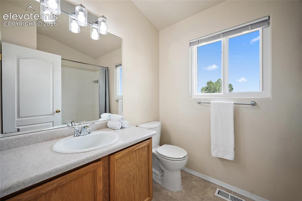 Image 21 of 41: Secondary full bathroom with vanity, tub and shower combination, natural li
