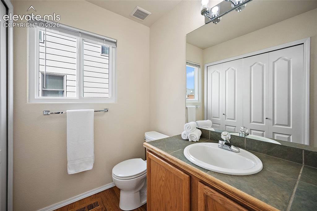 Image 25 of 41: Main-level half bath with window, large mirror, vanity, and convenient acce