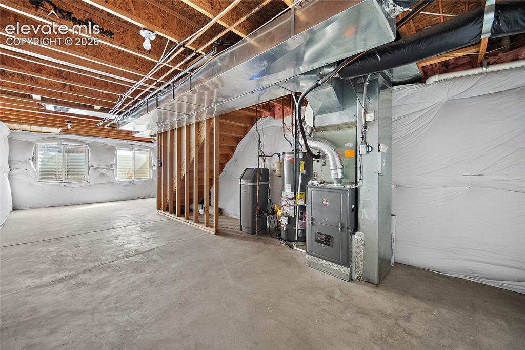 Image 26 of 41: Unfinished basement with open floor area, existing mechanical systems, and
