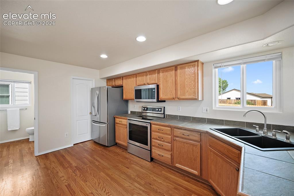 Image 6 of 41: Kitchen view highlighting the oak cabinetry, stainless steel appliances, do