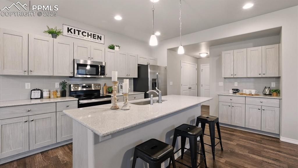 Image 18 of 47: The Island Kitchen features a pantry, counter bar, and cabinets with quartz