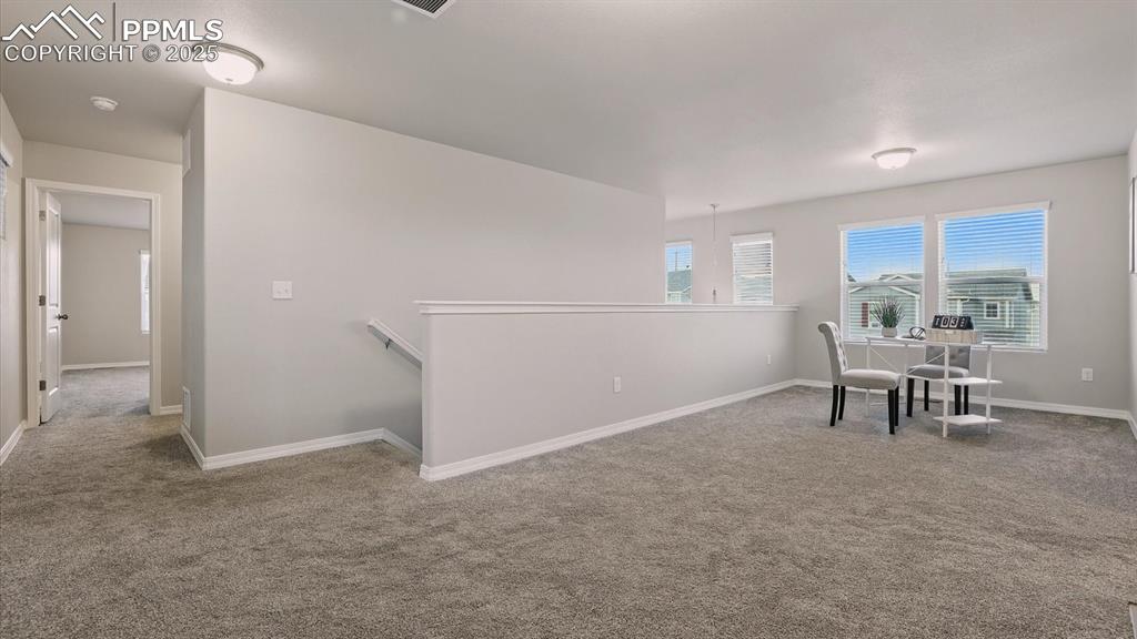 Image 22 of 47: Spacious Loft with neutral carpet and windows that bring lots of natural li
