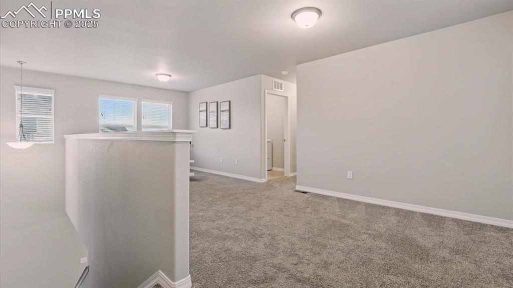 Image 24 of 47: Upper Level Loft with view into the Laundry Room.