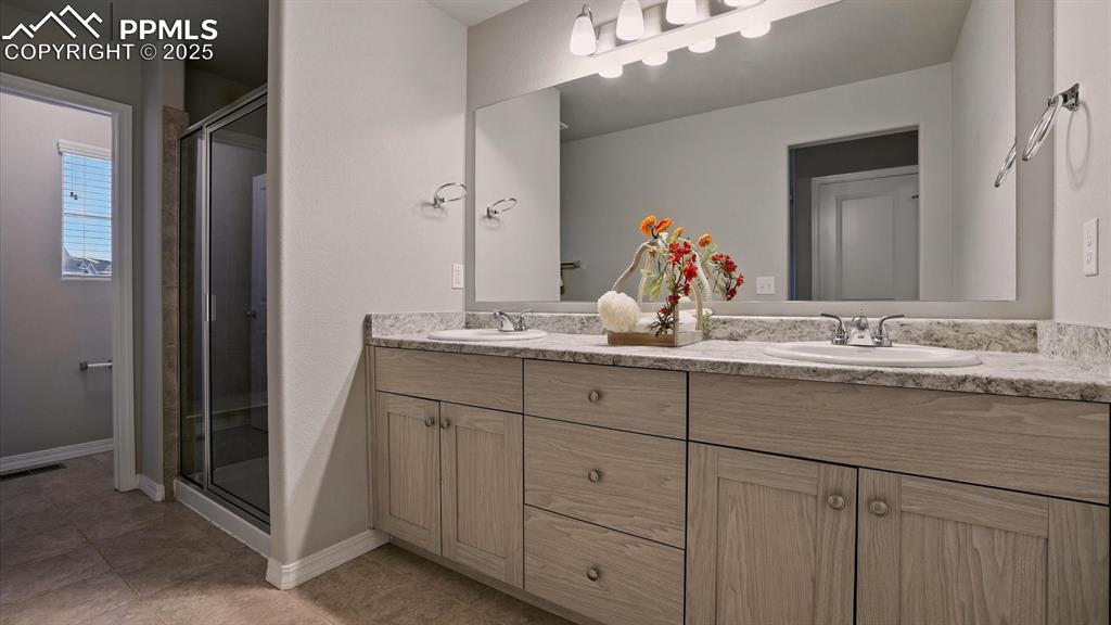 Image 30 of 47: Spa Shower Bathroom with a dual sink vanity and walk-in tiled shower with b