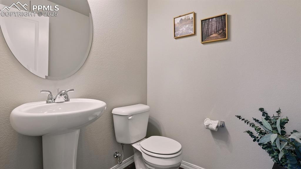 Image 8 of 47: Powder Bathroom with pedestal sink off the front entry.