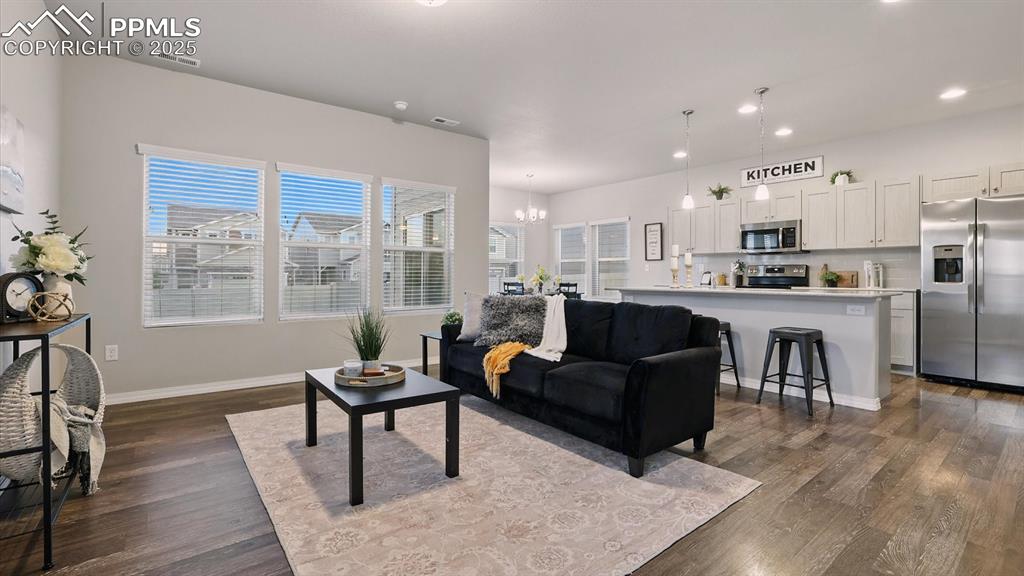 Image 9 of 47: The Living Room flows effortlessly into the into the Kitchen and Dining Roo