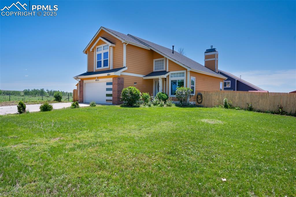Image 2 of 50: View of front of house featuring a garage, driveway, and a chimney