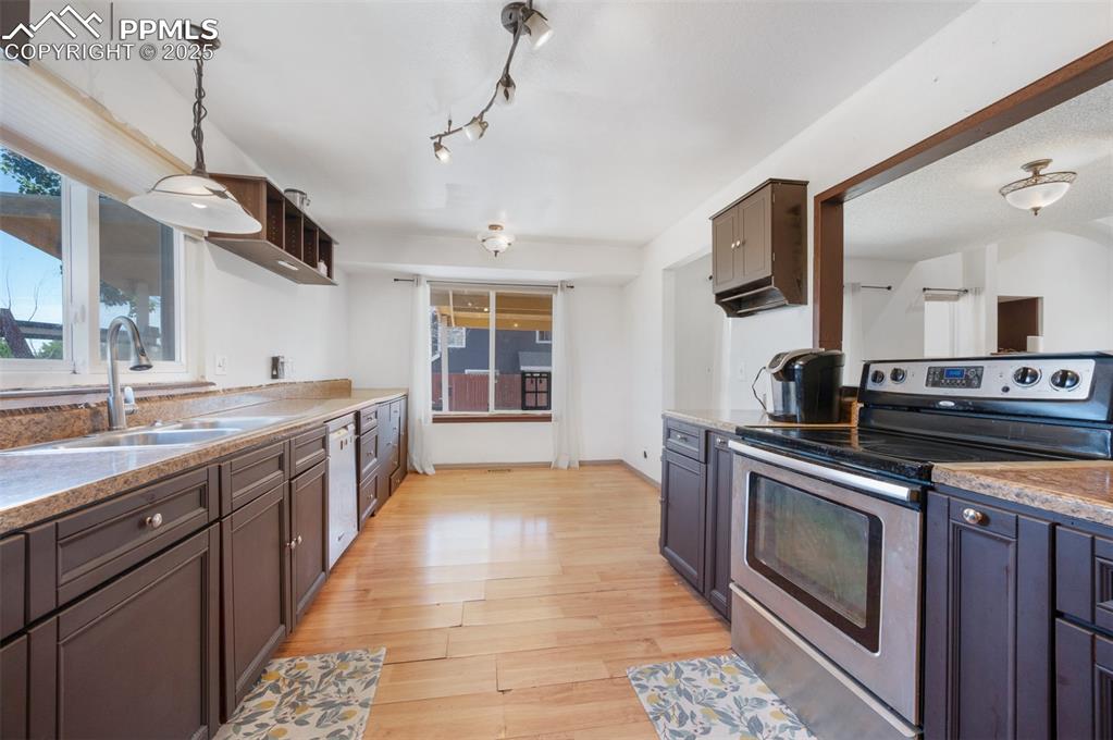 Image 25 of 50: Kitchen with electric range, light wood-type flooring, dishwasher, hanging