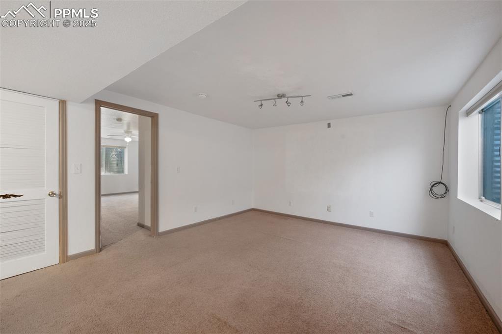 Image 31 of 50: Unfurnished room with light colored carpet, plenty of natural light, and ra