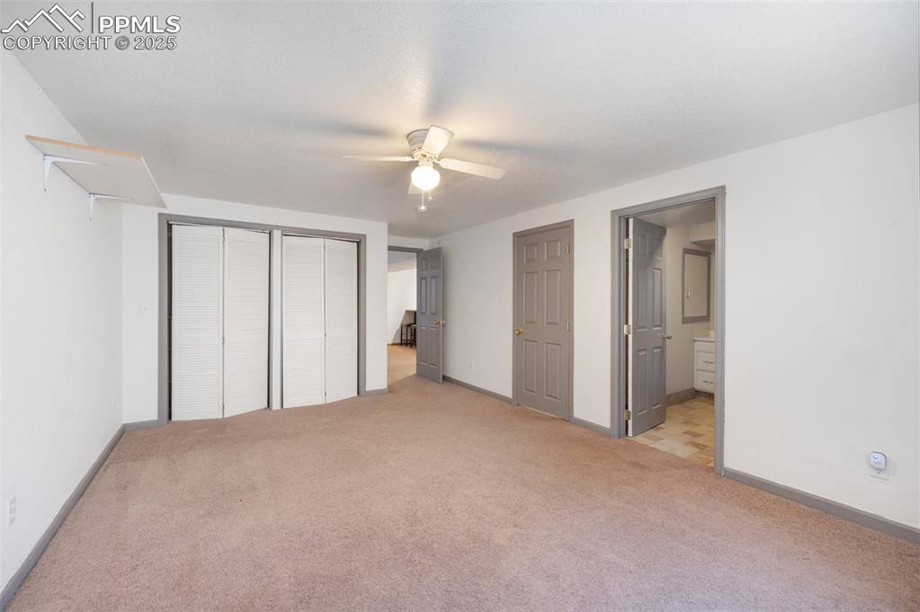Image 35 of 50: Unfurnished bedroom with carpet flooring, a ceiling fan, a closet, and conn
